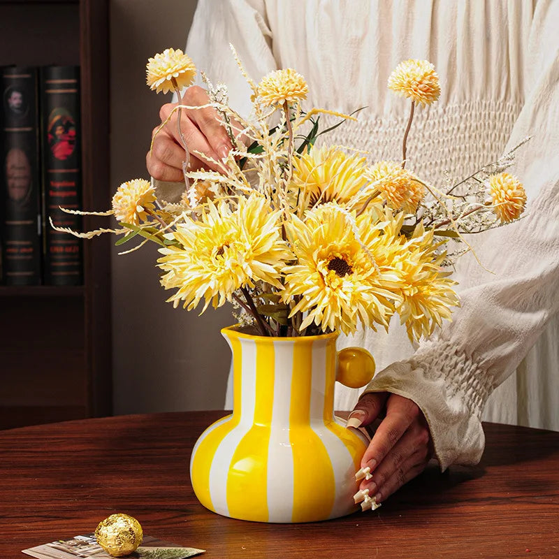 Collection of striped ceramic pitcher vases in green red blue black and yellow with flowers