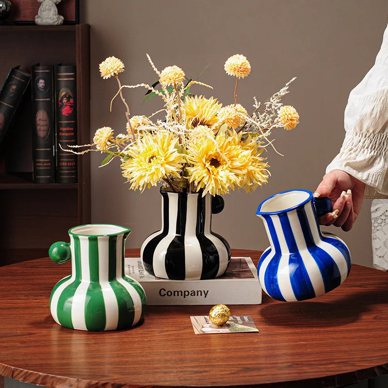 Collection of striped ceramic pitcher vases in green red blue black and yellow with flowers